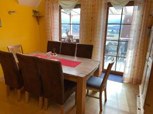 a dining room with a wooden table and chairs at Pension-Gästehaus Küblböck in Neualbenreuth