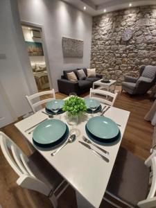 a dining room with a white table and chairs at Placeta Apartments in Dubrovnik