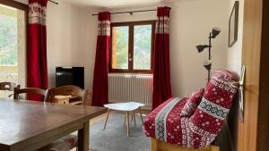 a living room with red curtains and a dining room table at Edelweiss de Vallouise-Pelvoux, 52m2 in Pelvoux