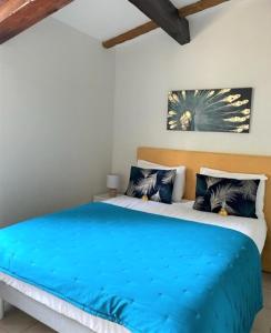 1 dormitorio con 1 cama con manta azul en auberge du castellas en Sainte-Croix-du-Verdon