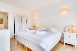a white bedroom with a large white bed and a window at Ses Alzines Apartment - Costa De Los Pinos in Costa des Pins