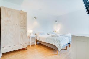 een witte slaapkamer met een bed en een kast bij Ses Alzines Apartment - Costa De Los Pinos in Costa des Pins