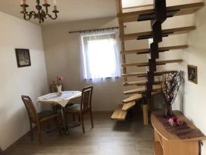 a dining room with a table and a spiral staircase at Austeria Zakościele in Inowłódz