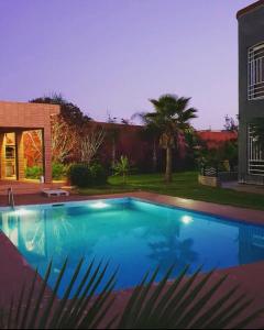 una gran piscina azul en un patio en Belle maison de campagne en Kenitra