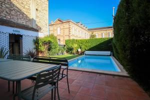 a patio with a table and chairs and a swimming pool at Evasion in Albi