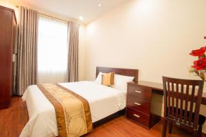 - une chambre avec un lit, un bureau et une fenêtre dans l'établissement Green Garden Residence Hotel, à Đà Nẵng