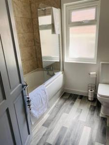 a bathroom with a shower and a toilet and a window at Barry Townhouse in Barry