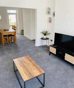 a living room with a flat screen tv and a table at Barry Townhouse in Barry