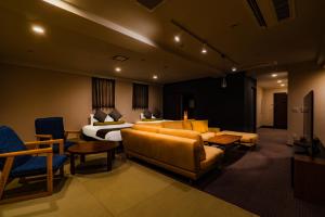 a hotel room with a bed and a couch and chairs at Randor Residence Susukino Suites in Sapporo