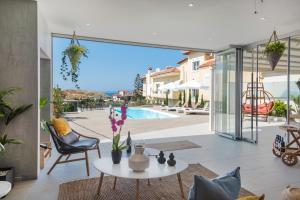un soggiorno con tavolo, sedie e piscina di Sea view villa with private pool close to the beach a Karteros