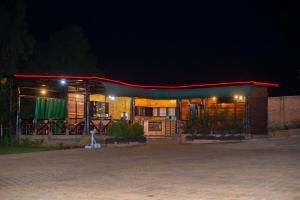 a small building with a red roof at night at QUALITY INN HOTEL Kigali in Kigali