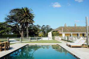 a swimming pool with chairs and a house at Mount William Station in Willaura