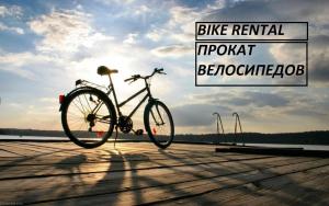 una bicicleta estacionada en un paseo marítimo de madera con un cartel en Dream House & Hostel, en Sevan