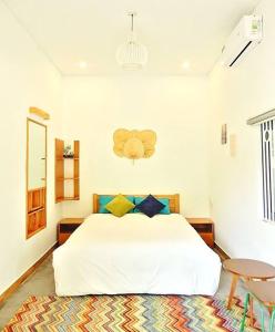 1 dormitorio con cama blanca y mesa en Crest House Beachside - Three-bedroom Private House on Cham Island Hoi An, en Tân Hiệp