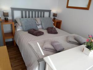 Un dormitorio con una cama con almohadas. en Cleeves Cabins Ailsa Lodge with hot tub luxury, en Dalry