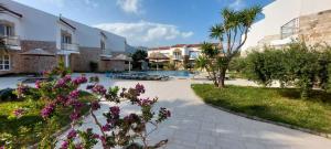 a resort with a swimming pool and flowers at Grapevines Villas Makrygialos in Makry Gialos