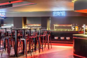 - un bar avec tabourets rouges dans un restaurant dans l'établissement Hotel Vibra District - Adults Only, à Sant Antoni de Portmany