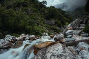 a mountain river with rocks and a waterfall at Odyssey Stays Ghangaria - 9Kms Trek from Pulna, Govindghat in Lokpāl