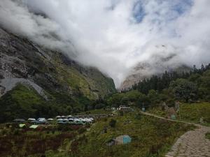 a group of cars parked in front of a mountain at Odyssey Stays Ghangaria - 9Kms Trek from Pulna, Govindghat in Lokpāl