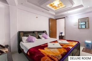 a bedroom with a large bed with purple pillows at Odyssey Stays Ghangaria - 9Kms Trek from Pulna, Govindghat in Lokpāl