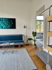 een woonkamer met een blauwe bank en een tafel bij WELL Pretty Places - sustainable interior design in the Citycenter in Kassel