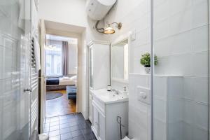 Un baño blanco con lavabo y espejo. en Luxurious Apartments At City Center, en Budapest