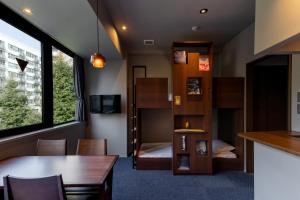 a room with a table and a room with a bunk bed at COCOSHUKU Shinjuku-Hanazono in Tokyo