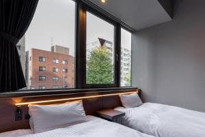 Postel nebo postele na pokoji v ubytování COCOSHUKU Shinjuku-Hanazono