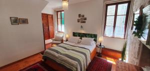 a bedroom with a bed and two windows at B&B Palace Basilico 1580. in Rovinj