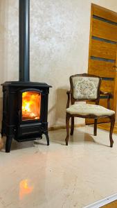 a wood stove with a chair and a fireplace at Gemütliches Apartment mit Kamin und Wohnküche in Herzberg am Harz