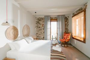 a bedroom with a large white bed and a chair at Filanthi - The project in Methoni