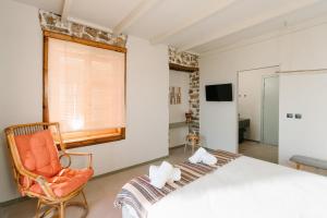 a bedroom with a large bed and a chair at Filanthi - The project in Methoni