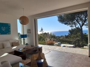 - un salon avec un canapé et une grande fenêtre dans l'établissement VILLA ANADINE - Aiguebonne BOULOURIS - PLEINE VUE MER - À 5 minutes à pied de la plage - Climatisée, à Saint-Raphaël