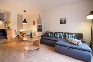 uma sala de estar com um sofá e uma mesa em Ferienwohnung am Swatten Diek 36 FeWo 2 em Cuxhaven