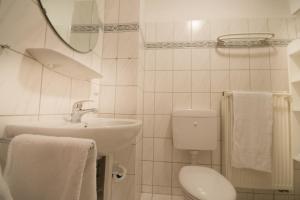 uma casa de banho branca com um WC e um lavatório em Ferienwohnung am Swatten Diek 36 FeWo 2 em Cuxhaven