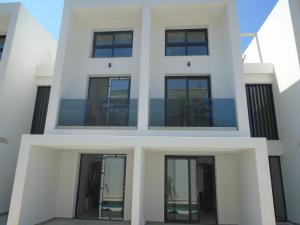 a white building with glass windows on it at ASTERIAS Apartment in Kallithea Halkidikis