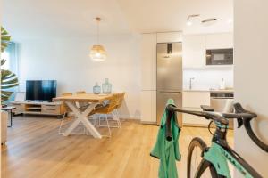 uma sala de jantar e cozinha com uma mesa e uma bicicleta em Bravissimo Gerió, 2-bedroom apartment em Girona