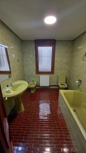 een badkamer met een toilet, een wastafel en een bad bij Apartamento Gernika in Guernica y Luno