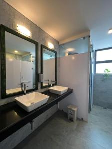 a bathroom with two sinks and a large mirror at VIBE Hostels in Colombo
