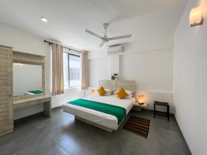 a white bedroom with a bed and a window at VIBE Hostels in Colombo