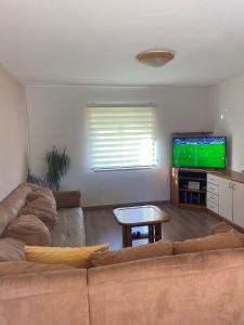 a living room with a couch and a flat screen tv at Apartman Ana Kali in Kali