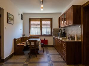 a kitchen with a table and a dining room at Mamutfenyő Panzió in Tata