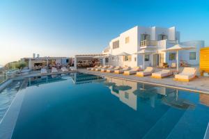 una piscina con sillas y un edificio en IL Vento Premium, en Mykonos ciudad