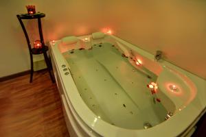 a jacuzzi tub with candles in a room at Africana Hotel & Spa in Borg El Arab