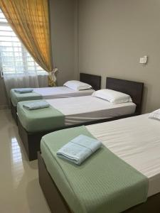 a group of four beds in a room at Dca villa homestay in Kota Bharu