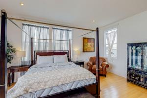 a bedroom with a canopy bed and a chair at The Coquille River Retreat in Bandon