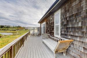 a porch of a house with a bench on it at The Coquille River Retreat in Bandon