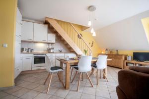 eine Küche mit einem Tisch und Stühlen sowie eine Treppe in der Unterkunft Ferienwohnung Hamburger Straße 7OG in Cuxhaven in Cuxhaven