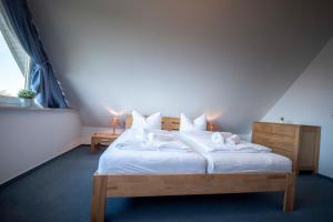 Schlafzimmer mit einem Bett mit weißer Bettwäsche und Kissen in der Unterkunft Ferienwohnung Hamburger Straße 7OG in Cuxhaven in Cuxhaven