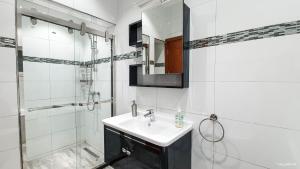 a white bathroom with a sink and a shower at Deluxe Résidence Ouaga 2000 in Ouagadougou +129 photos